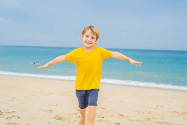 เด็กชายมีความสุขบนชายหาดดูเครื่องบินลงจอด เดินทางบนเครื่องบินที่มีแนวคิดเด็ก — ภาพถ่ายสต็อก