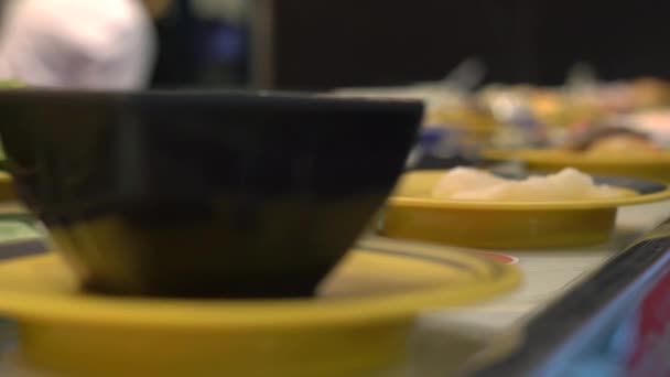 Food conveyor. Asian style cafe with food moving on a conveyor in a little plates. Concept of food wasting. wasting Concept of overeating — Stock Video