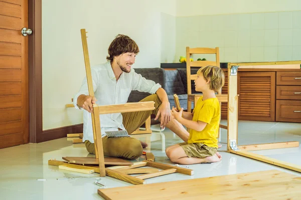 Padre e hijo ensamblando muebles. Un chico ayudando a su padre en casa. Concepto de familia feliz — Foto de Stock