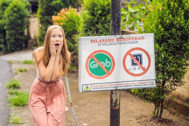 Bali, Endonezya - 21 Mayıs, 2018: protesto bakar genç kadın üye bir duvar içinde Uber için itiraz Endonezya dili ve kapmak taksi şoförleri okur Uber ve kapmak taksiler girilmez Ubud, Bali, Endonezya