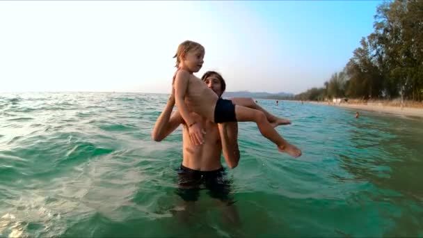 Superslowmotion tiro de um pai jogando seu filho no mar — Vídeo de Stock