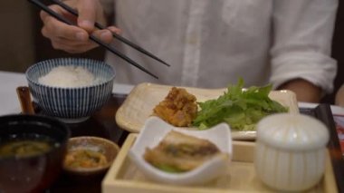 Japon-Kore kafede bir genç adam eatimg Asya gıda kadeh Slowmotion
