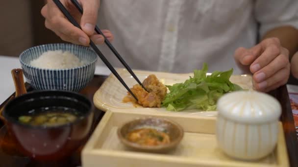 Zeitlupenaufnahme eines jungen Mannes, der asiatisches Essen in japanisch-koreanischem Café isst — Stockvideo