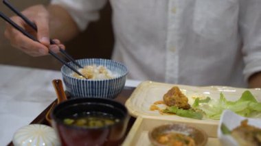 Japon-Kore kafede bir genç adam eatimg Asya gıda kadeh Slowmotion