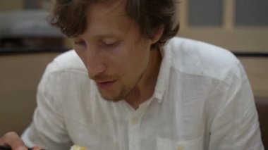 Japon-Kore kafede bir genç adam eatimg Asya gıda kadeh Slowmotion.
