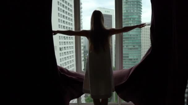 Superslowmotion shot of successful rich young woman opening curtains in her downtown apartment with panoramic view. Success concept. Fulfilled life concept — Stock Video