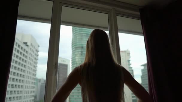 Superslowmotion shot of successful rich young woman standing by the window in her downtown apartment with panoramic view. Success concept. Fulfilled life concept in her downtown apartment. Success — Stock Video