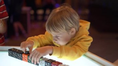 Küçük bir çocuk çocuklar için Bilim Müzesi ziyaret Slowmotion vurdu. Modüler bir robot ile oynuyor