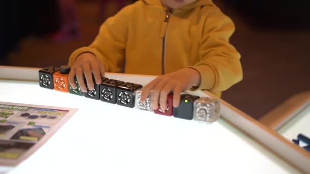 Slowmotion βολή από ένα μικρό αγόρι που επισκέπτονται ένα μουσείο επιστήμης για τα παιδιά. Παίζει με ένα αρθρωτό ρομπότ — Αρχείο Βίντεο