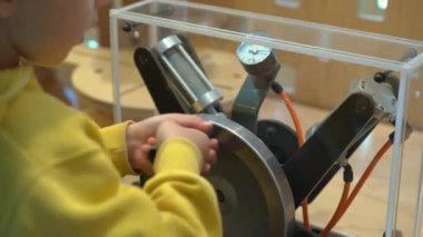 Küçük çocuk çocuklar için Bilim Müzesi ziyaret etti. Oraya bir plastik şişe yapmak için el pompası ile hava sıkıştırır
