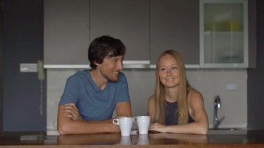 Genç çift erkek ve kadın bir mutfakta eğlenceli ve kahkaha var.