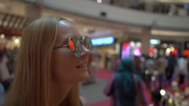 Superslowmotion girato di una giovane donna in un centro commerciale durante il Lunare, Capodanno cinese tempo di celebrazione. Riflessioni di lanterne rosse nei suoi occhiali da sole — Video Stock