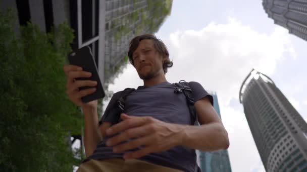 Superslowmotion disparo de una mujer joven thar utilizar un teléfono inteligente en el centro de la ciudad con rascacielos en un segundo plano. Navegación a través del concepto de ciudad. Concepto de transporte público. Concepto de reserva de taxi — Vídeo de stock