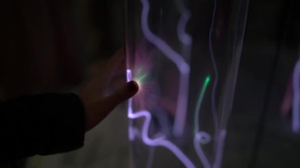 Installation dans un musée des sciences. Prise de vue au ralenti d'une main d'une femme en train de tauffer le tube avec du gaz lumineux. émission de lumière de gaz inerte. tube avec un plasma lumineux — Video