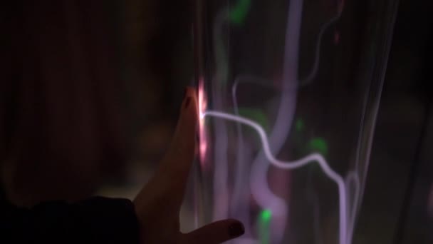 Инсталляция в научном музее. Медленный снимок руки женщины, обжигающей трубку светящимся газом. инертное газовое излучение. трубка с пылающей плазмой — стоковое видео