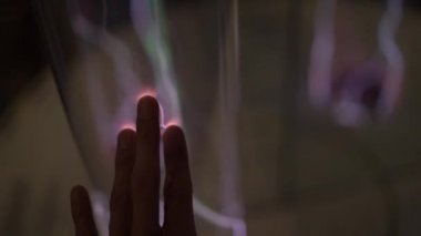 Yükleme bir Bilim Müzesi'nde. Bir kadın tauching ile parlayan gaz tüp bir el Slowmotion vurdu. inert gaz ışık emisyon. parlayan bir plazma ile tüp