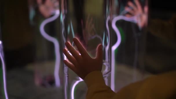 Instalación en un museo de ciencias. Disparo en cámara lenta de una mano de una mujer tocando el tubo con gas brillante. emisión de luz de gas inerte. tubo con un plasma brillante — Vídeo de stock