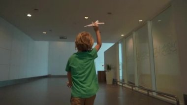 Koşmak-den geçerek beyaz oyuncak uçak elinde tutan Havaalanı Slowmotion atış küçük bir çocuk. Özgürlük kavramı. Çocukluk kavramı. Çocuklar seyahat kavramı