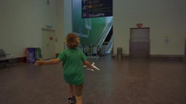 Kuala Lumpur, Malezya - 20 Kasım 2018: Slowmotion koşmak-den geçerek Havaalanı holding beyaz oyuncak uçak elinde küçük bir çocuk vurdu. Özgürlük kavramı. Çocukluk kavramı. Çocuklar seyahat kavramı