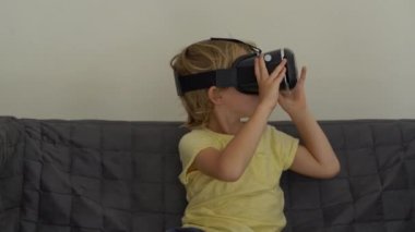 Tatlı küçük bir çocuk kullanımları bir sanal gerçeklik kulaklık vurdu. VR gözlük. VR kavramı. Çocuk ve modern teknoloji kavramı