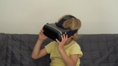 Tatlı küçük bir çocuk kullanımları bir sanal gerçeklik kulaklık vurdu. VR gözlük. VR kavramı. Çocuk ve modern teknoloji kavramı