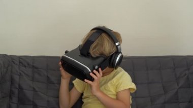 Tatlı küçük bir çocuk kullanımları bir sanal gerçeklik kulaklık vurdu. VR gözlük. VR kavramı. Çocuk ve modern teknoloji kavramı