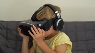 Tatlı küçük bir çocuk kullanımları bir sanal gerçeklik kulaklık vurdu. VR gözlük. VR kavramı. Çocuk ve modern teknoloji kavramı