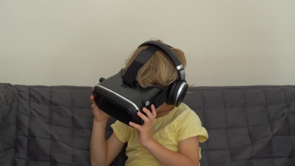 Closeup shot of a little boy uses a virtual reality headset. VR glasses. VR concept. Children and modern technology concept — Stock Video