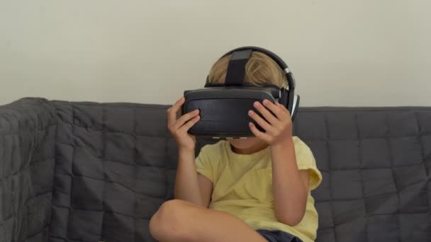 Крупный план маленького мальчика использует гарнитуру виртуальной реальности. Стаканы виртуальной реальности. Концепция виртуальной реальности. Дети и современная технология — стоковое видео