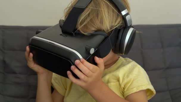 Closeup shot of a little boy uses a virtual reality headset. VR glasses. VR concept. Children and modern technology concept — Stock Video