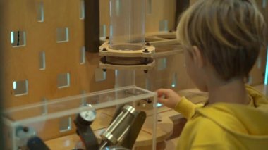 Küçük bir çocuk çocuklar için Bilim Müzesi ziyaret Slowmotion vurdu. Oraya bir plastik şişe yapmak için el pompası ile hava sıkıştırır