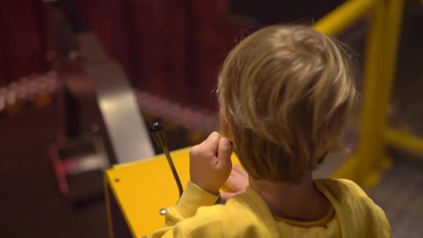 Slowmotion βολή από ένα μικρό αγόρι που επισκέπτονται ένα μουσείο επιστήμης για τα παιδιά. Αγόρι παίζει με ένα μοντέλο του ένα εκσκαφέα. Τα παιδιά προσπαθούν διαφορετικά επαγγέλματα έννοια — Αρχείο Βίντεο