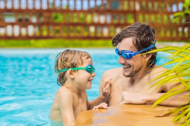 Baba ve oğlu içinde gözlük yüzme havuzunda eğlenin