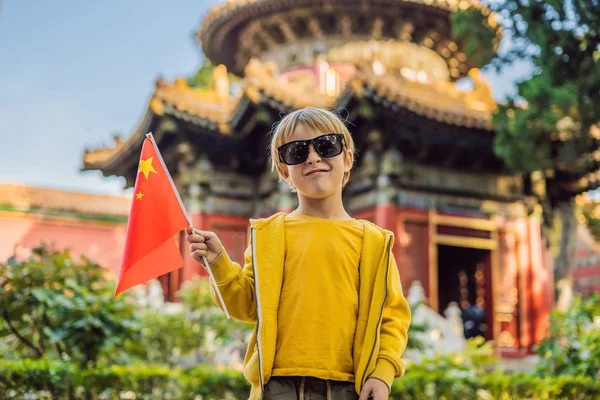 Enjoying vacation in China. Young boy with national chinese flag in Forbidden City. Travel to China with kids concept. Visa free transit 72 hours, 144 hours in China