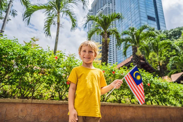 Boy travels in malaysia with malaysia flag celebrating the Malaysia independence day and Malaysia day. Travel to Malaysia concept