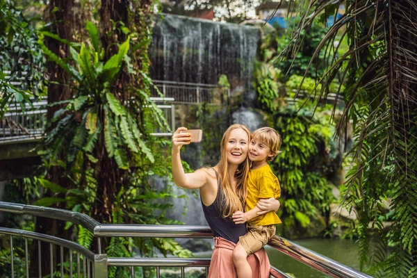Mãe e filho tirar uma selfie no fundo de uma cachoeira — Fotografia de Stock