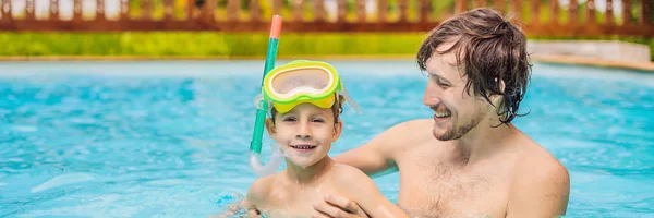 Dad and son in swimming Goggles have fun in the pool BANNER, LONG FORMAT