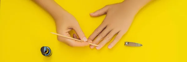 Женский уход за руками. Top View Of Beautiful Smooth Womans Hands with Professional Nail Care Tools for Manicure On yellow Background. Крупный план здоровых женских ногтей с желтым лаком для ногтей. Высокий — стоковое фото