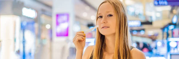 Женщина с бумажными полосками в руках слушает аромат в торговом центре BANNER, LONG FORMAT — стоковое фото