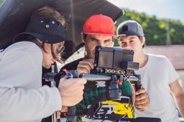 Steadicam Operatörü ve Yardımcısı bir ticari çekmek için kamera ve 3 eksenli sabitleyici-gimbal hazırlamak