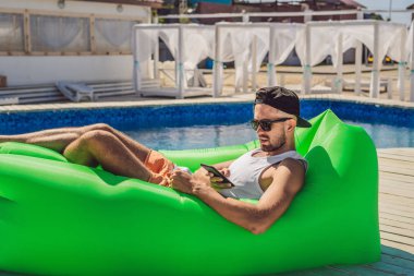 Boş zaman zevk, havuz kenarında hava Divan Lamzac, yalan genç adam.