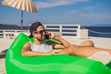 Boş zaman zevk, denize yakın air koltuk Lamzac, yatan genç adam.