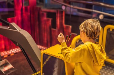 Çocuk bir büyük oyuncak ekskavatör ile oynuyor. İnşaat kavramı. Çocuk geliştirme kavramı