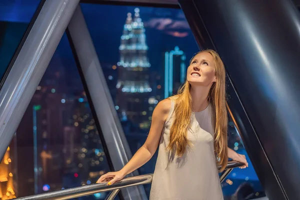 Woman looks at Kuala lumpur cityscape. Panoramic view of Kuala Lumpur city skyline evening at sunset skyscrapers building in Malaysia — Stock Photo, Image