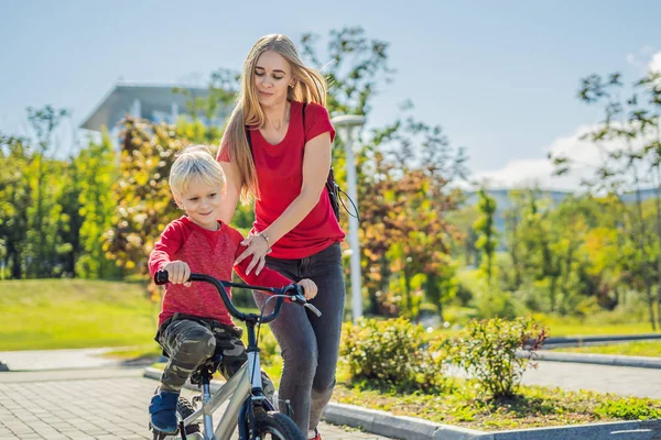 Молодая Мать Учит Своего Сына Кататься Велосипеде Парке — стоковое фото
