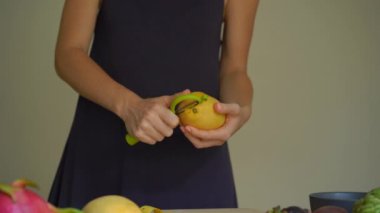 4 x Slowmotion atış mango peeling genç bir kadının kez ve tropikal meyve bir sürü bir açayım.