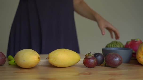 Il rallentatore di una giovane donna stende frutti tropicali sul tavolo — Video Stock