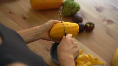 2 x Slowmotion atış mango küpleri ve tropikal meyve bir sürü kesme genç bir kadının kez açayım