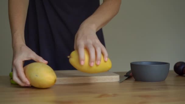 Slowmotion skott av en ung kvinna lägger ut tropiska frukter på bordet — Stockvideo