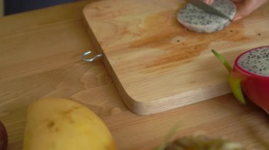 4 x Slowmotion shot dragon meyve küpler içine kesme ve gri bir seramik kasenin içine koyarak genç bir kadının kez ve tropikal meyve bir sürü bir açayım